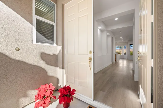 a hallway with pink flowers and wooden floor