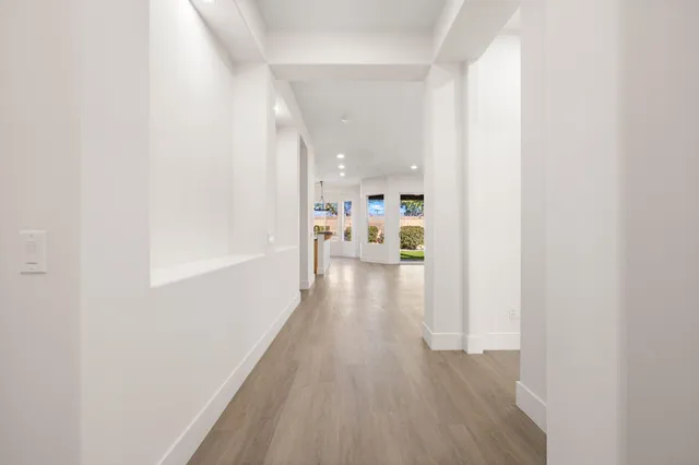 a view of a hallway with wooden floor a fireplace and a window