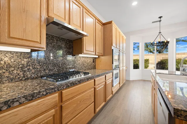 a kitchen with stainless steel appliances granite countertop a stove a sink and a refrigerator