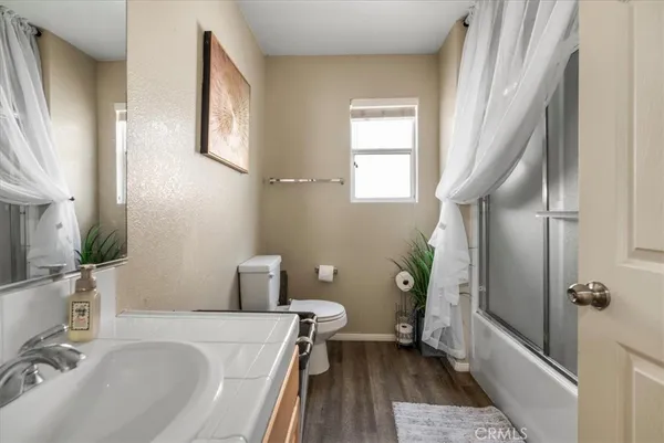 a bathroom with a sink a toilet and a window