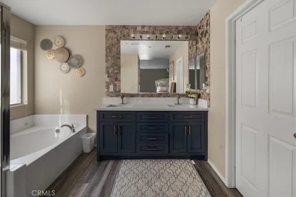 a bathroom with a tub sink and mirror