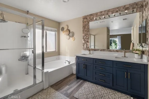 a spacious bathroom with a tub sink shower and mirror