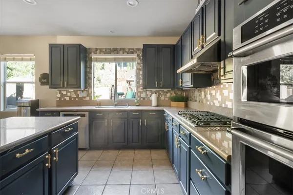 a kitchen with a sink stove top oven and cabinets