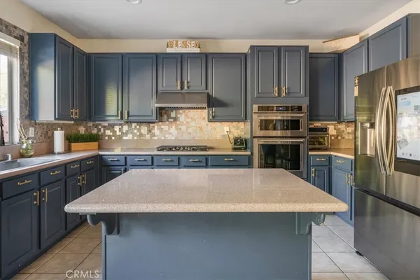 a kitchen with stainless steel appliances wooden floor sink stove and refrigerator