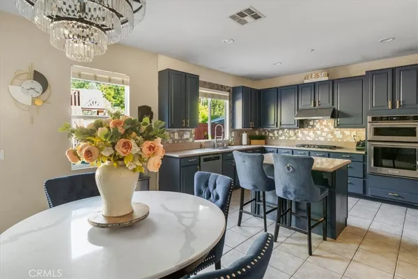 a kitchen with a dining table chairs and chandelier