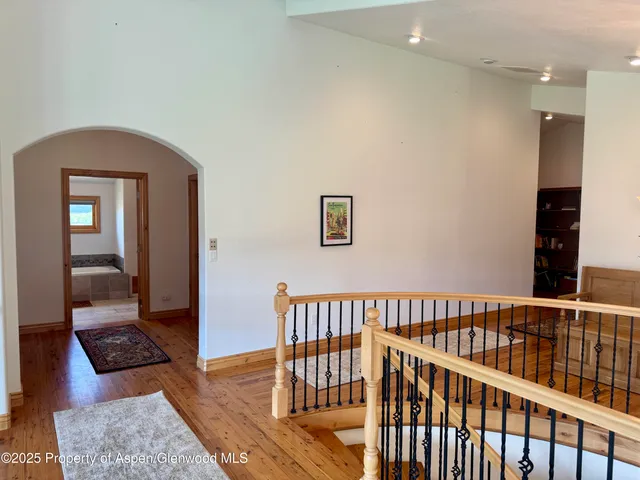 a view of a hallway with wooden floor and windows