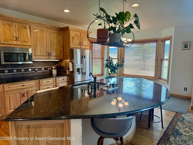 a view of a dining room with furniture a kitchen and chandelier