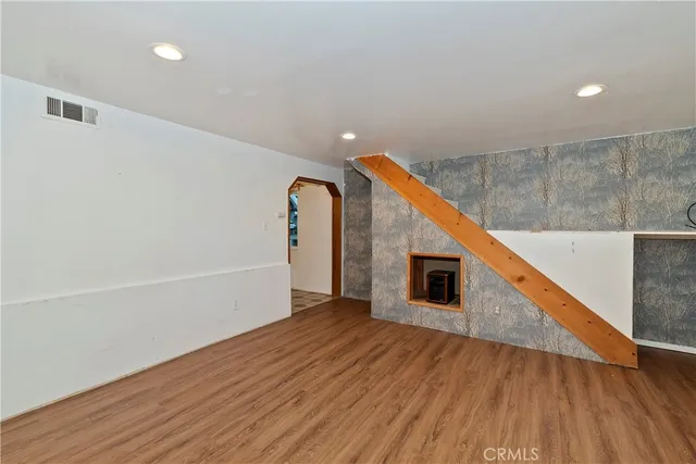 a view of a hallway with wooden floor and staircase