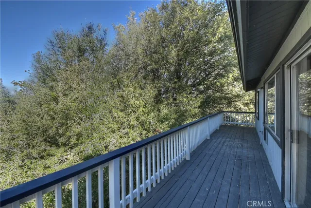 a view of a balcony with wooden floor and fence