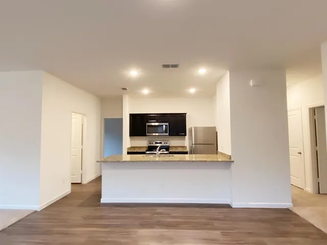 a kitchen with granite countertop stainless steel appliances and wooden cabinets