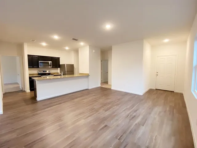 a kitchen with a sink dishwasher a stove and a refrigerator with wooden floor