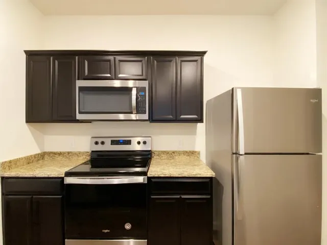 a view of a big room with wooden floor and windows