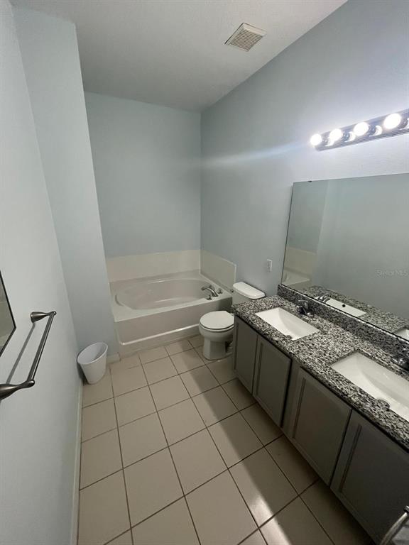 435 Kettering Road Davenport, FL 33897 - Photo 5 of 8 a bathroom with a granite countertop sink toilet and shower