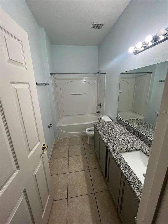 435 Kettering Road Davenport, FL 33897 - Photo 8 of 8 a bathroom with a granite countertop sink a toilet and shower