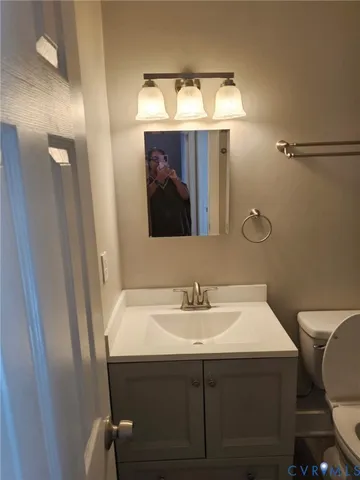 a bathroom with a sink mirror and toilet