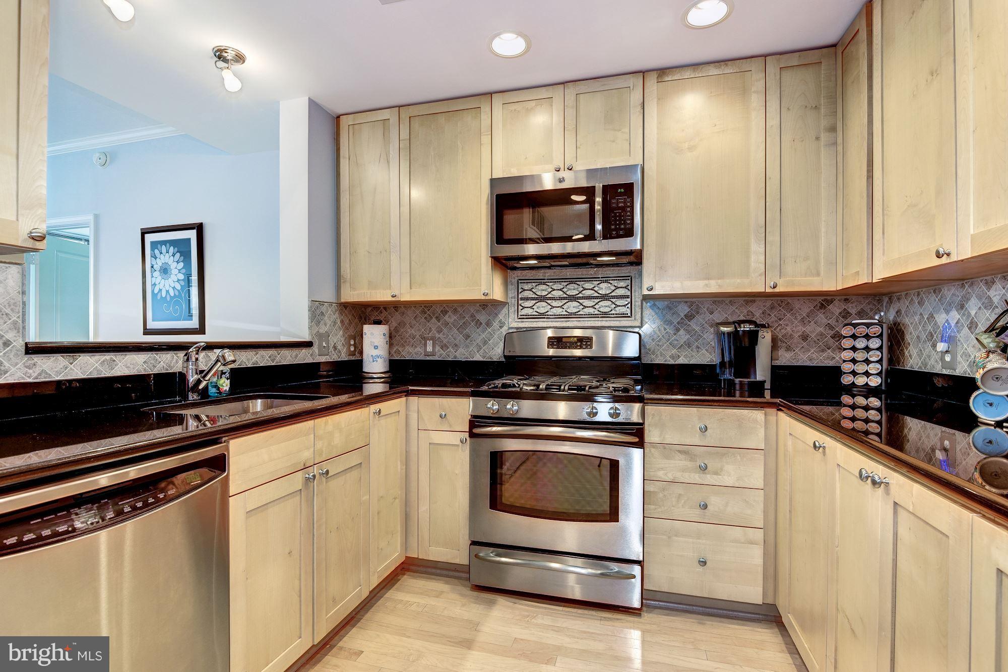 3600 South Glebe Road, Unit 918W Arlington, VA 22202 - Photo 3 of 30 a kitchen with stainless steel appliances granite countertop a stove a sink and a microwave