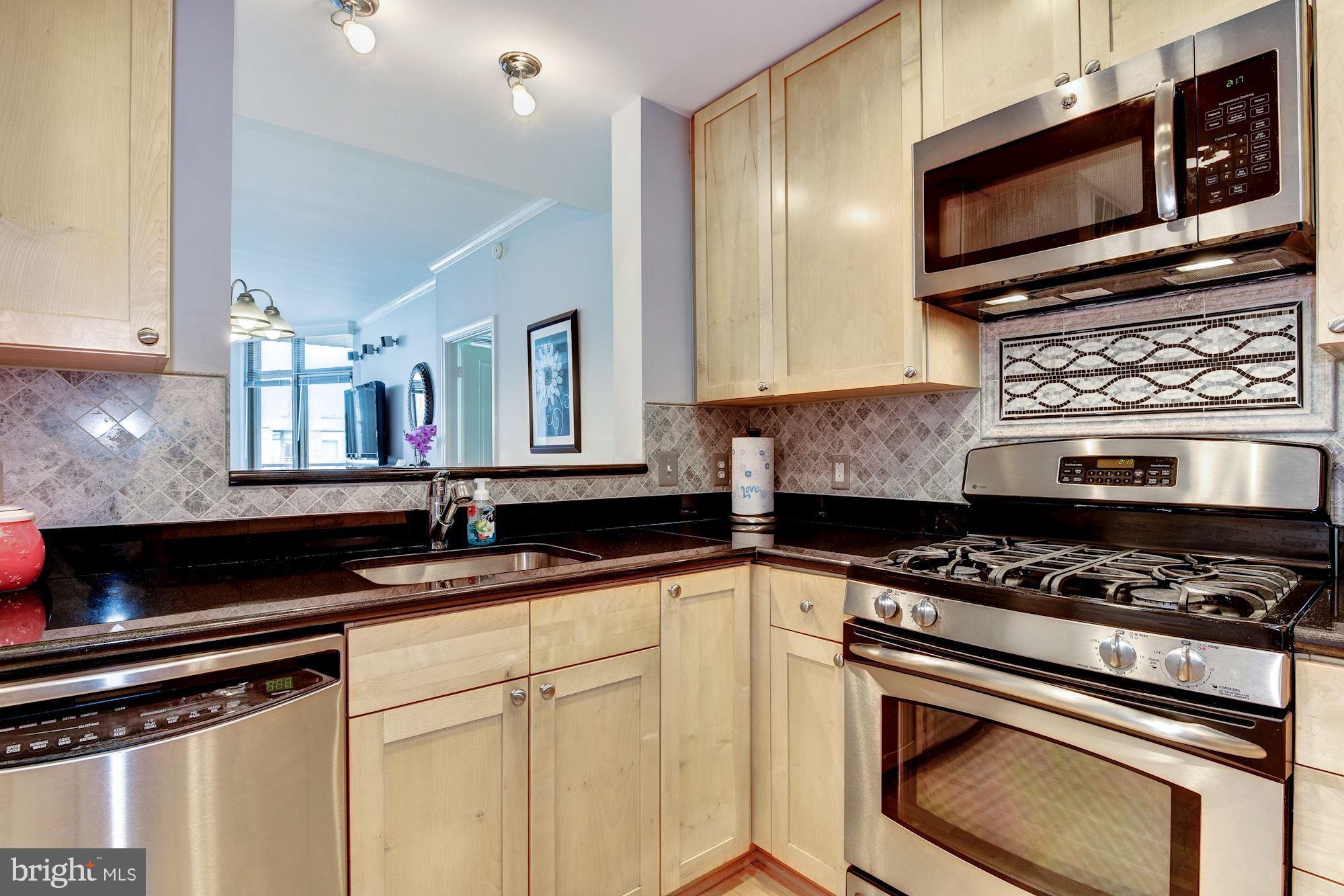 3600 South Glebe Road, Unit 918W Arlington, VA 22202 - Photo 5 of 30 a kitchen with stainless steel appliances granite countertop a stove a microwave a sink and cabinets