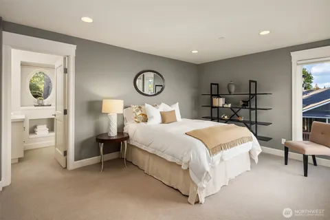 a bedroom with a bed and a lamp on dresser