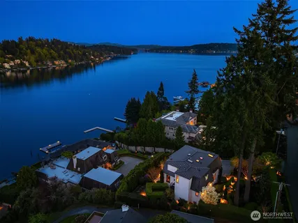 an aerial view of residential houses with outdoor space and lake view