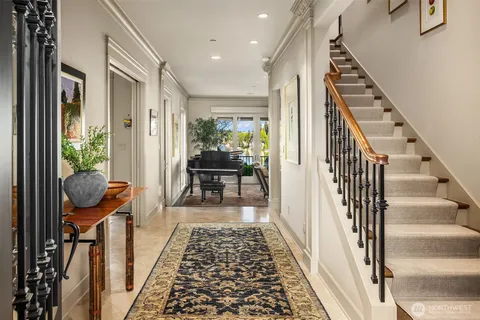 a view of a hallway to a livingroom with wooden floor and furniture