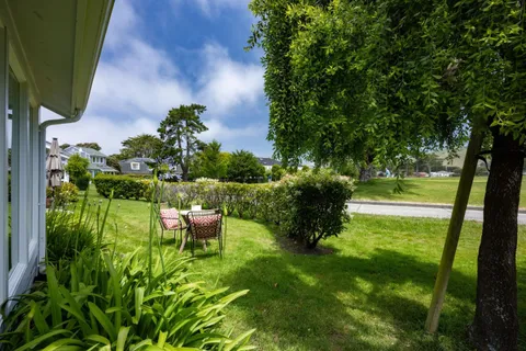 a view of a house with a backyard and sitting area