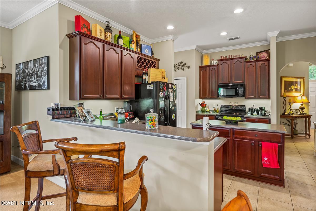 812 Riley Lane St. Augustine, FL 32095 - Photo 13 of 35 a kitchen with stainless steel appliances granite countertop a stove top oven a sink dishwasher and cabinets with wooden floor