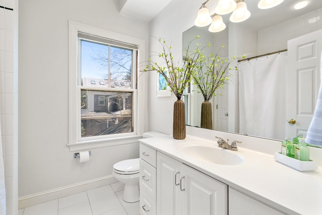 19 Elmore Street Newton, MA 02459 - Photo 27 of 40 a bathroom with a granite countertop sink a toilet and a mirror