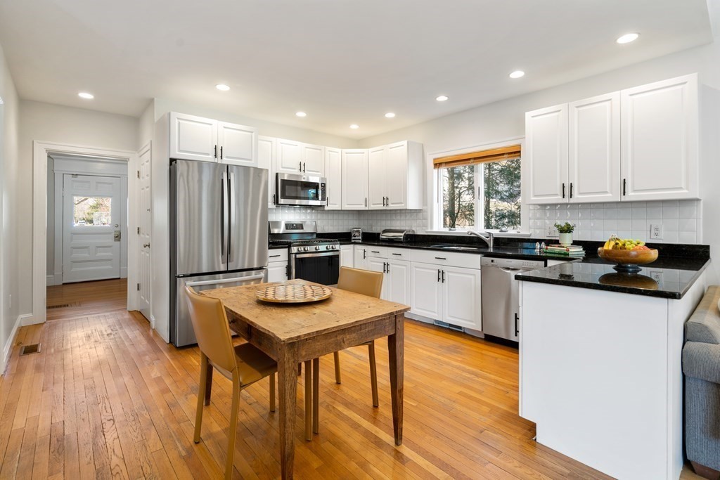 19 Elmore Street Newton, MA 02459 - Photo 9 of 40 a kitchen with stainless steel appliances granite countertop a refrigerator a stove top oven a sink dishwasher and white cabinets with wooden floor