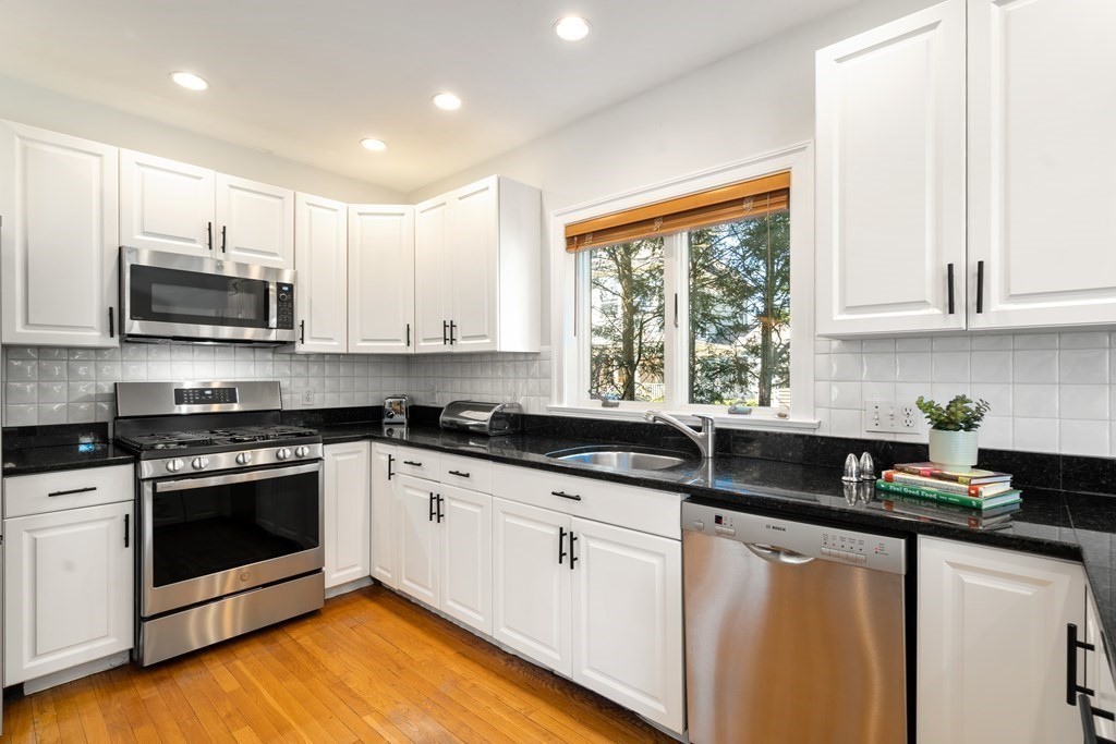 19 Elmore Street Newton, MA 02459 - Photo 10 of 40 a kitchen with stainless steel appliances granite countertop a sink a stove and cabinets