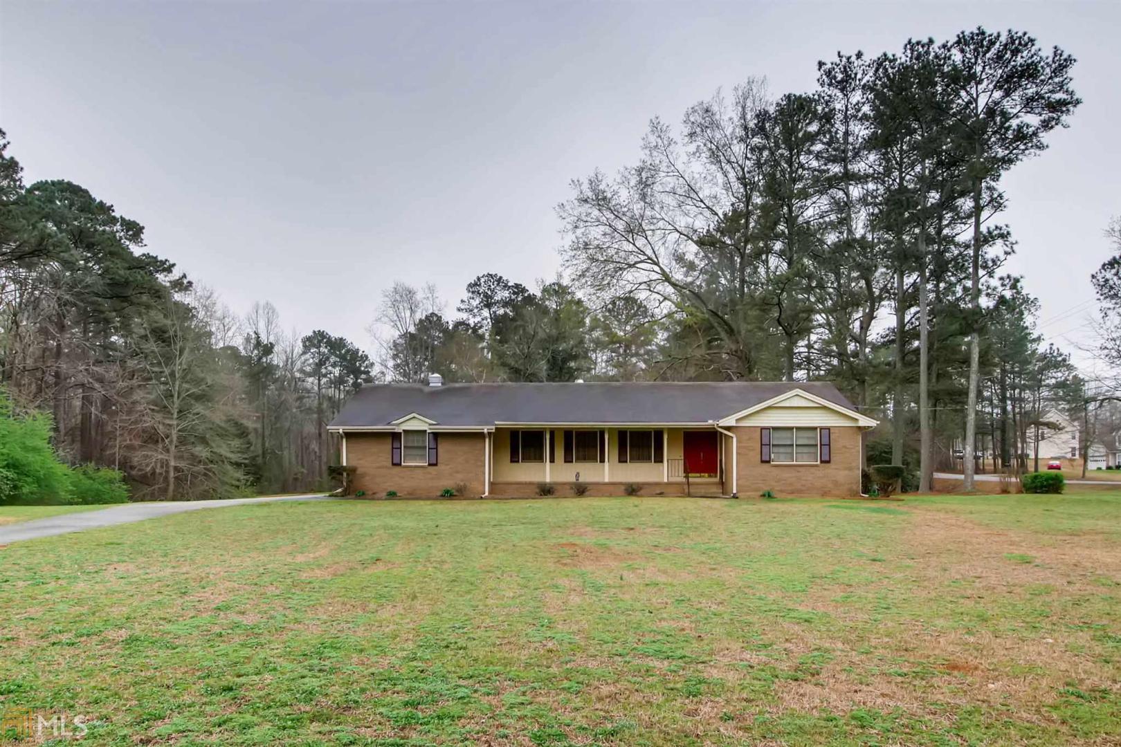 6750 Rivertown Road Fairburn, GA 30213 - Photo 1 of 1 a front view of house with yard and trees in the background