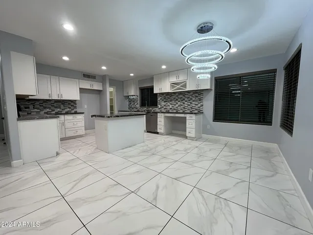 a large kitchen with stainless steel appliances kitchen island granite countertop a sink and cabinets