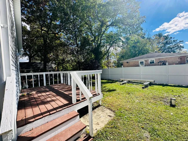a view of a roof deck with wooden fence and a couple of chairs