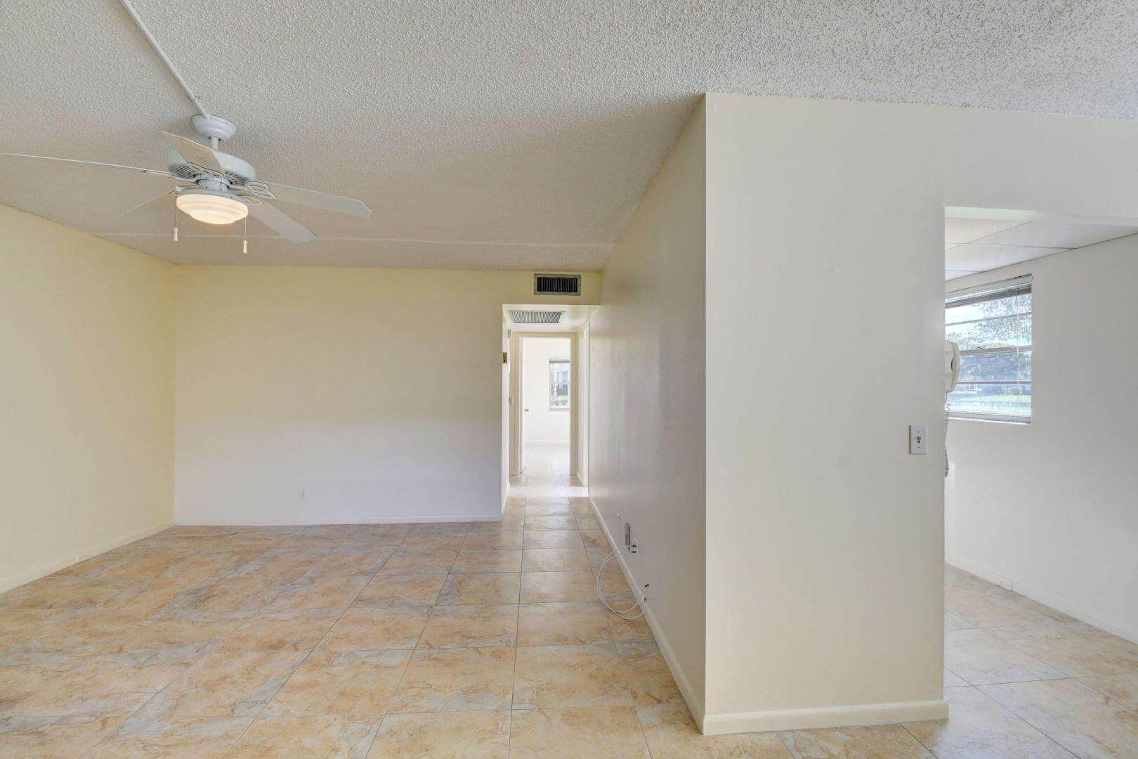 46 Brighton B Boca Raton, FL 33434 - Photo 11 of 50 en empty room with windows and ceiling fan