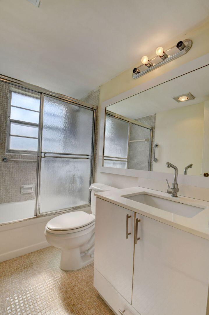46 Brighton B Boca Raton, FL 33434 - Photo 16 of 50 a bathroom with a sink a toilet and a mirror