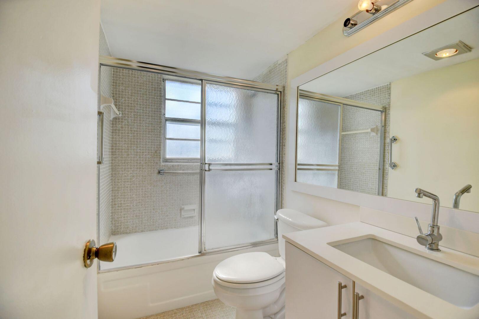 46 Brighton B Boca Raton, FL 33434 - Photo 17 of 50 a bathroom with a granite countertop sink toilet and shower