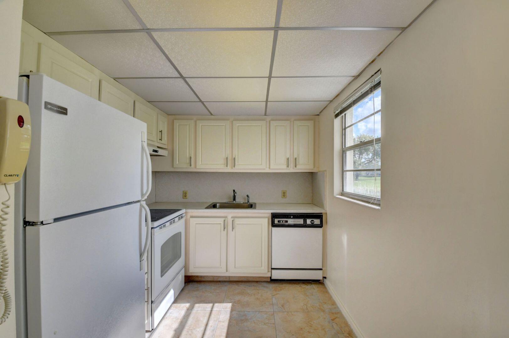 46 Brighton B Boca Raton, FL 33434 - Photo 4 of 50 a kitchen with a refrigerator a sink and cabinets