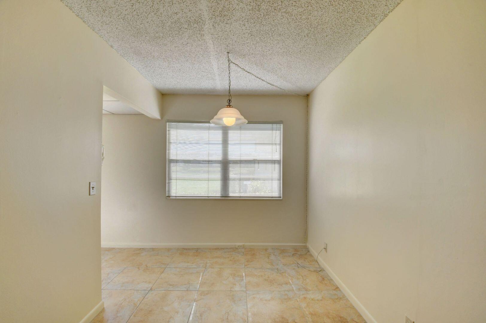 46 Brighton B Boca Raton, FL 33434 - Photo 6 of 50 an empty room with chandelier fan and windows