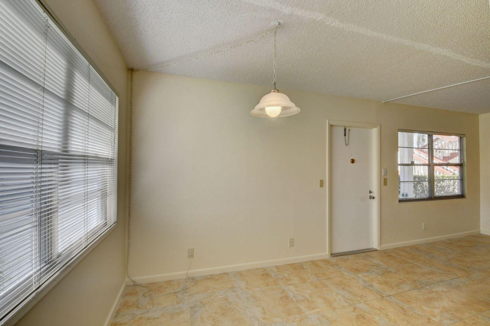 46 Brighton B Boca Raton, FL 33434 - Photo 9 of 50 a view of an empty room with window and chandelier fan