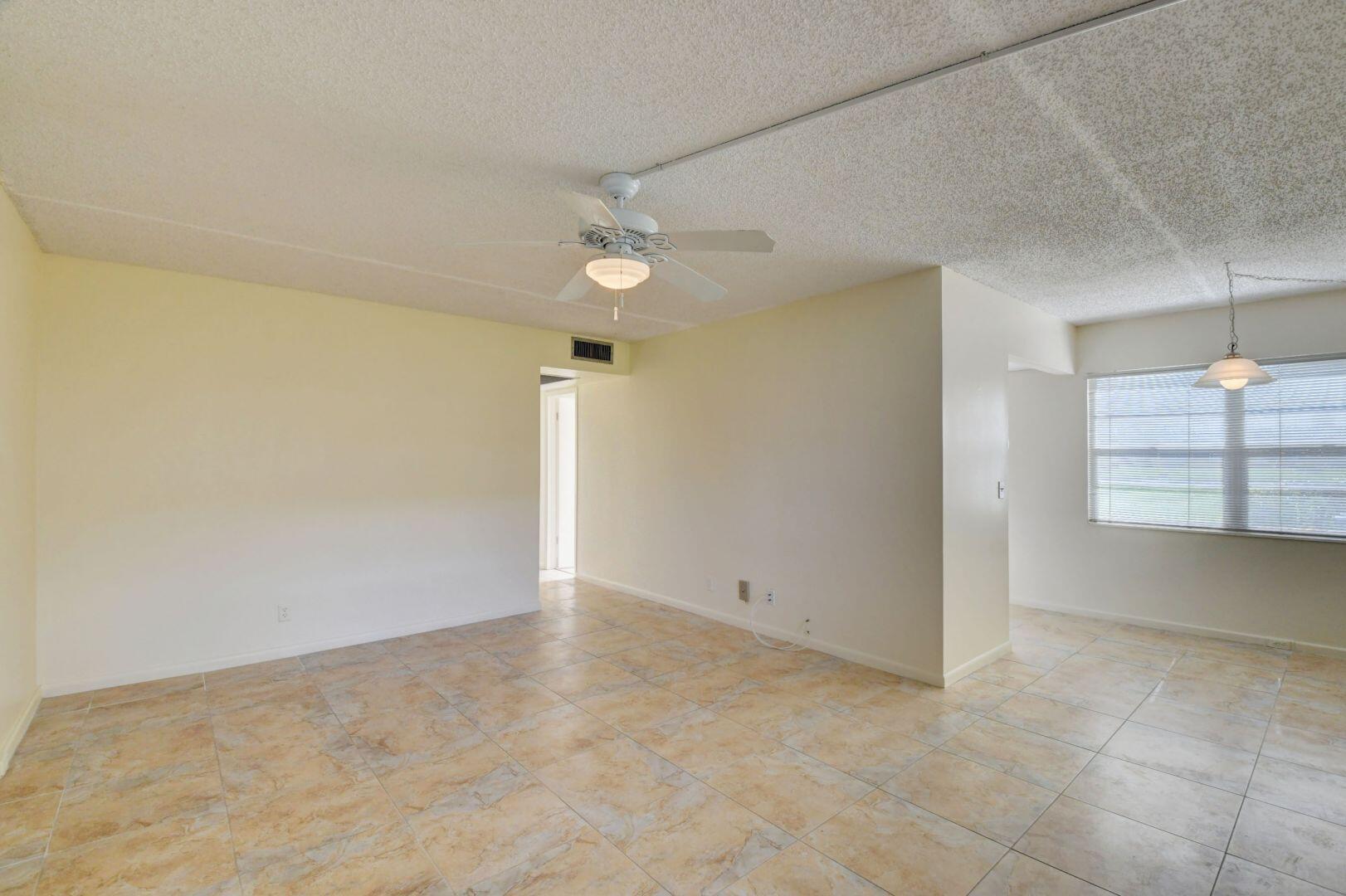 46 Brighton B Boca Raton, FL 33434 - Photo 10 of 50 an empty room with a ceiling fan and window