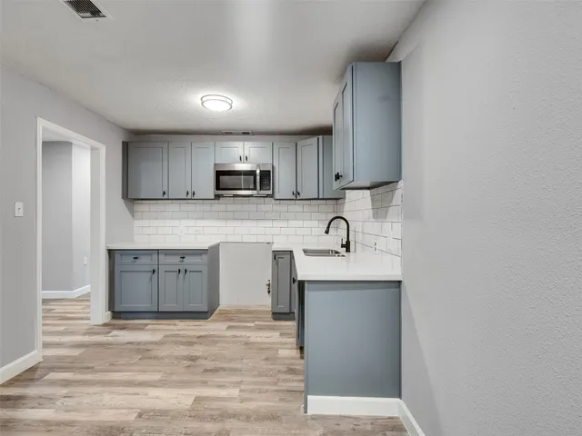 a kitchen with kitchen island a sink stainless steel appliances and cabinets