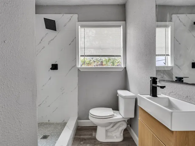 a bathroom with a toilet a sink and a window