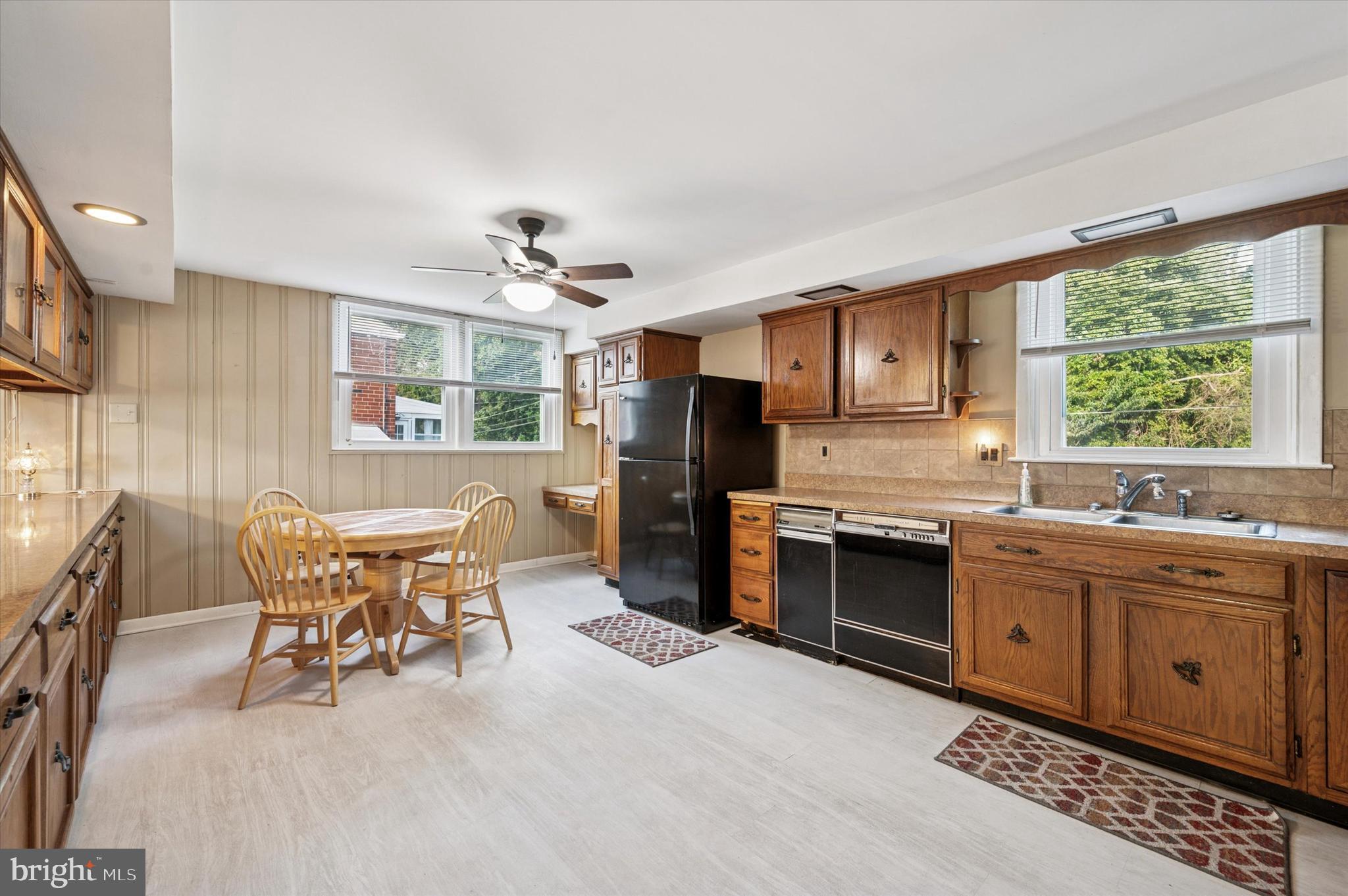 708 Cambridge Road Brookhaven, PA 19015 - Photo 5 of 20 a kitchen with stainless steel appliances granite countertop a stove top oven a sink dishwasher a dining table and chairs with wooden floor