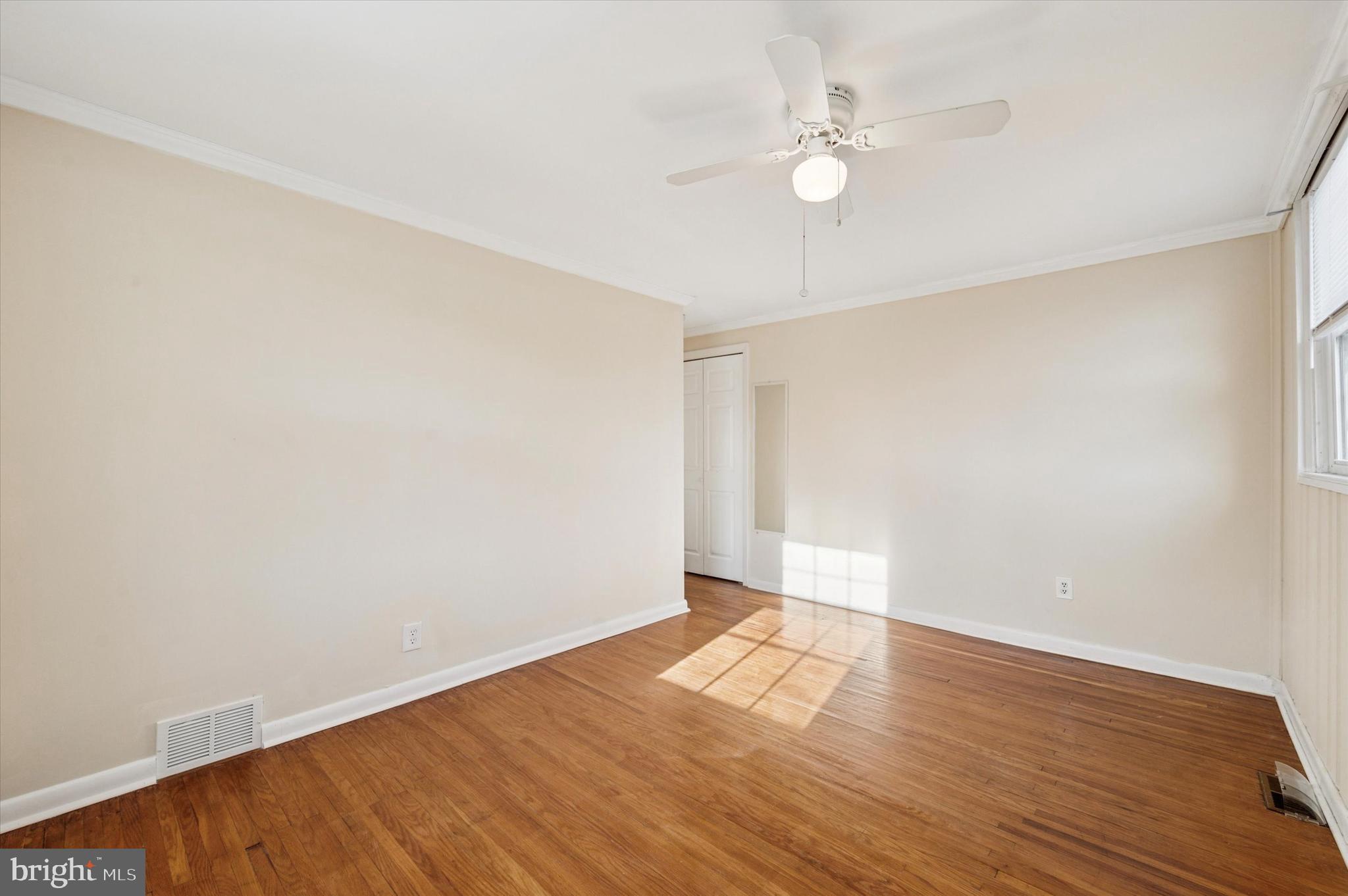708 Cambridge Road Brookhaven, PA 19015 - Photo 10 of 20 an empty room with wooden floor and fan