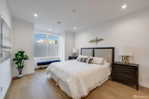 a bedroom with a bed and a potted plant