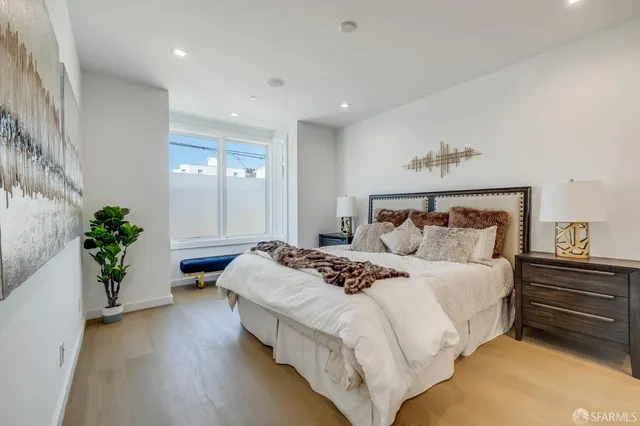 a bedroom with bed and a potted plant