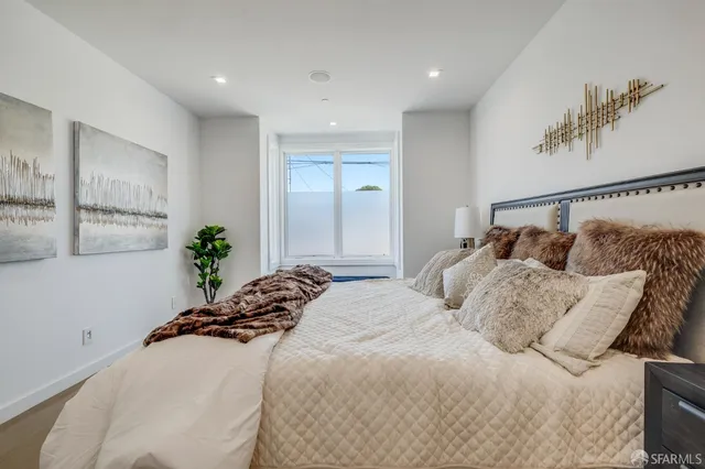 a bedroom with a bed and a painting on the wall