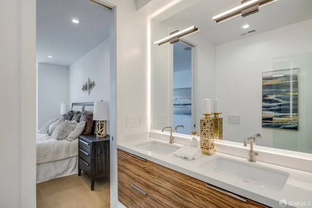 a en suite bathroom with a double vanity sink and a mirror