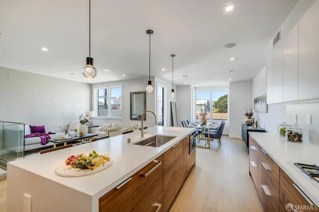 a large kitchen with kitchen island a stove a sink a dining table and chairs