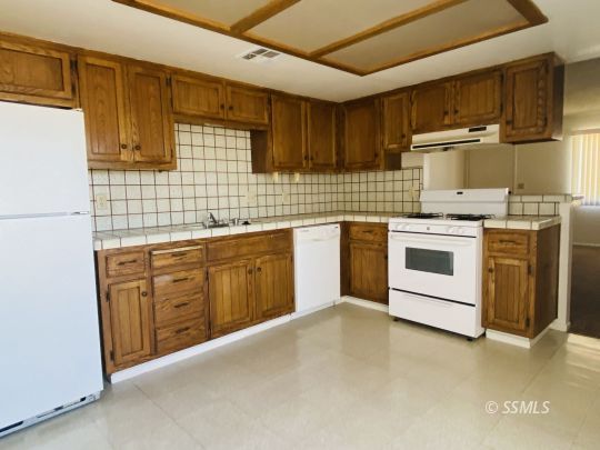 1004 West Graaf Avenue Ridgecrest, CA 93555 - Photo 18 of 21 a kitchen with stainless steel appliances granite countertop a stove sink and cabinets