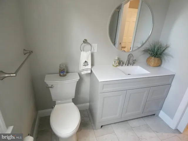 a bathroom with a granite countertop toilet and a shower